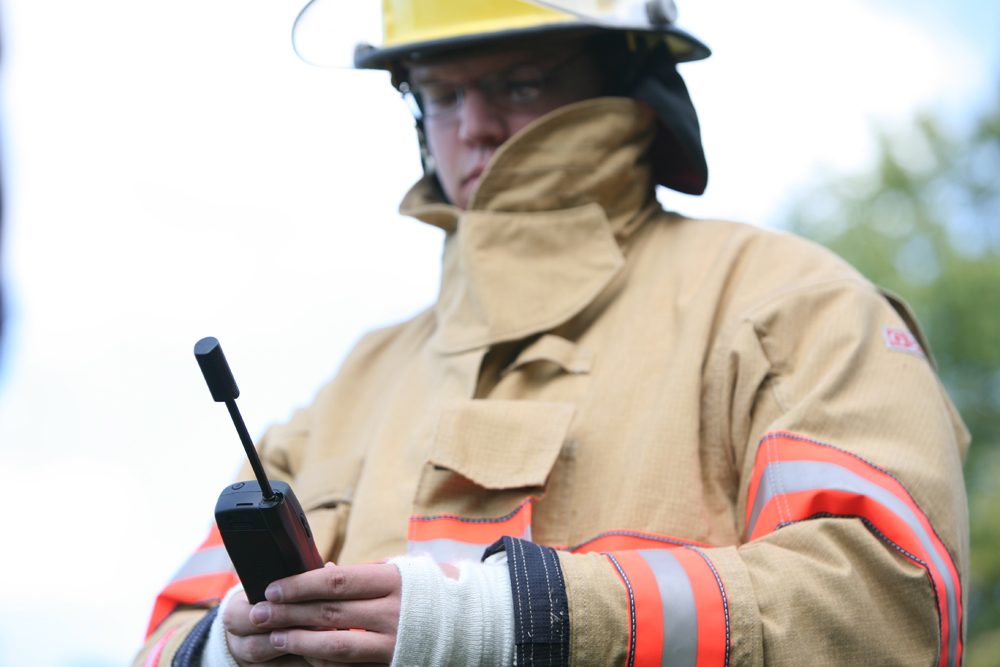 Professionnel de secours avec un téléphone satellite en main